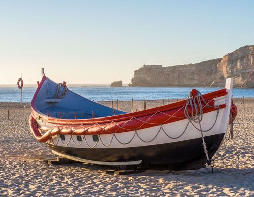 Traditional wooden boats on Nazare beach in Portugal