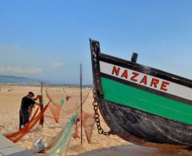 Traditional wooden boats on the sand at Nazare beach in Portugal